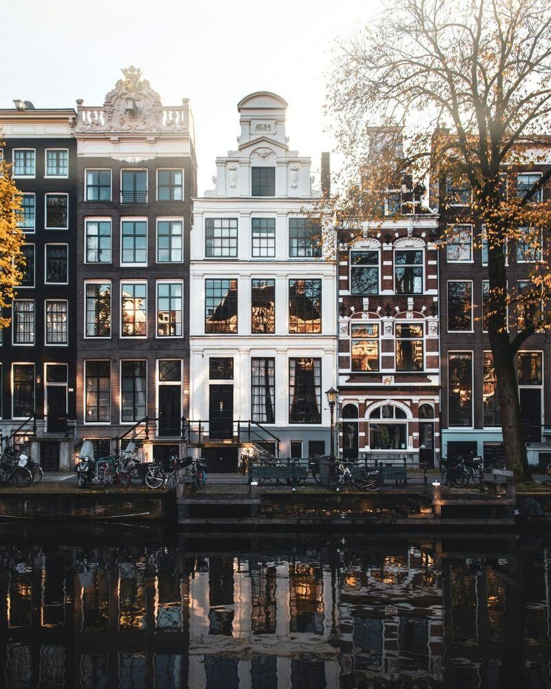 Amsterdam canal houses in autumn light, bicycles along the water